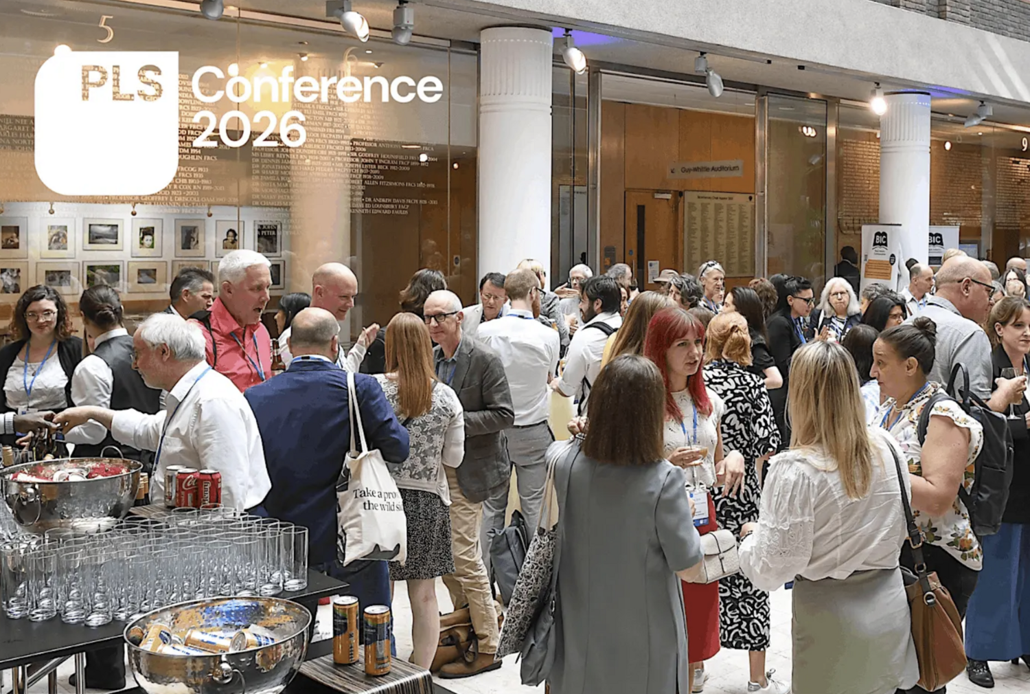 An image of conference attendees socialising and having drinks. In the corner is a white square PLS logo with the words 'Conference 2026' beside it.