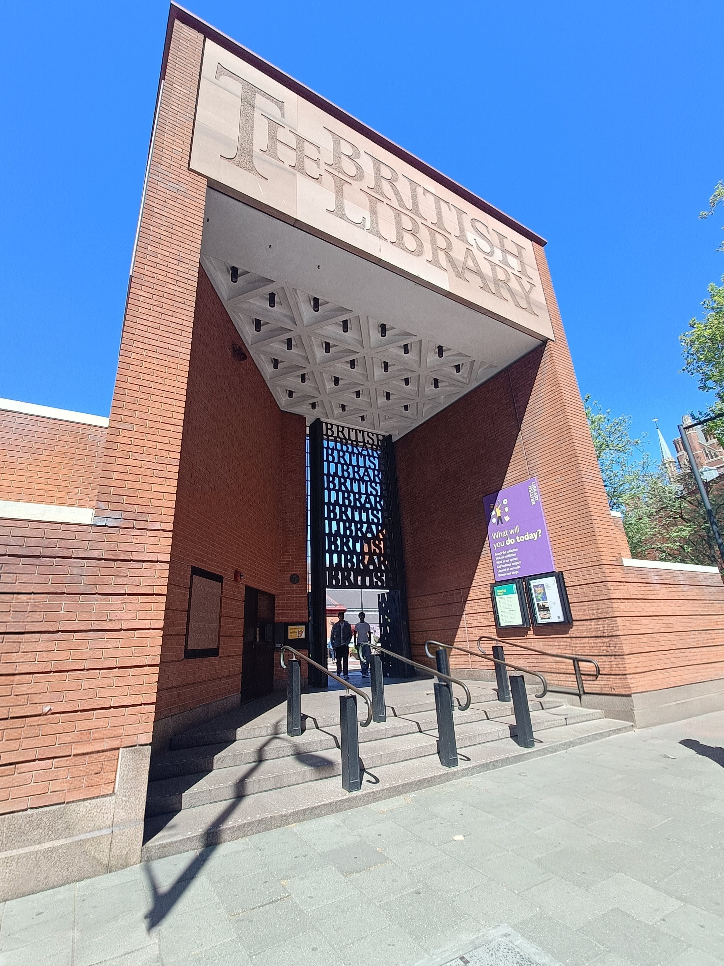 A picture of the entrance of The British Library with a blue sky behind.